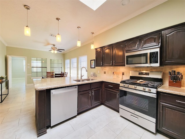 kitchen featuring a sink, a peninsula, tasteful backsplash, and stainless steel appliances