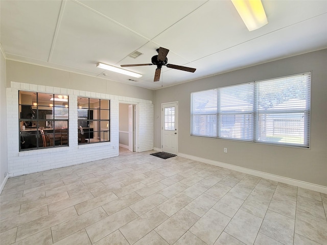 tiled spare room featuring visible vents, baseboards, and ceiling fan