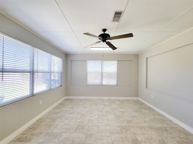 spare room with visible vents, plenty of natural light, baseboards, and a ceiling fan