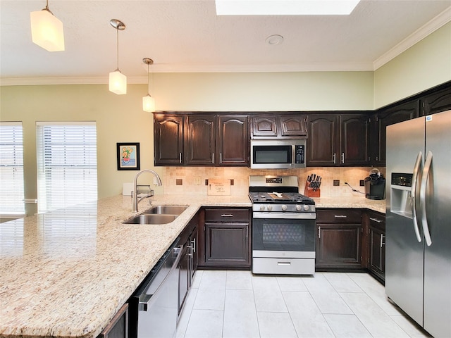 kitchen featuring a sink, backsplash, appliances with stainless steel finishes, and a peninsula