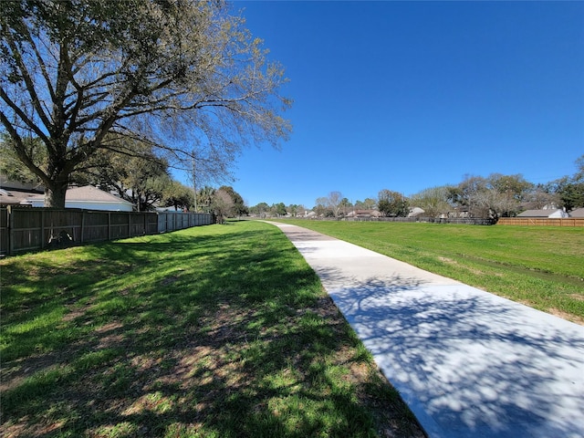 view of home's community featuring a lawn and fence