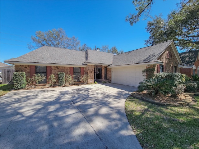 single story home with brick siding, driveway, an attached garage, and a shingled roof