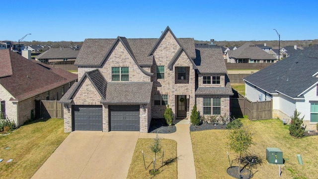 french country home featuring fence, a residential view, concrete driveway, a front yard, and brick siding