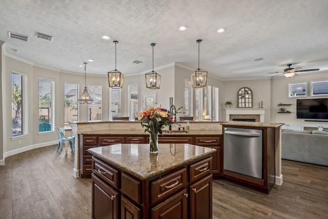 kitchen featuring stainless steel dishwasher, open floor plan, visible vents, and a center island with sink