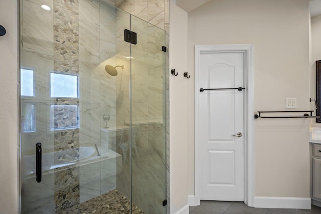 bathroom featuring tile patterned floors, baseboards, a stall shower, and vanity