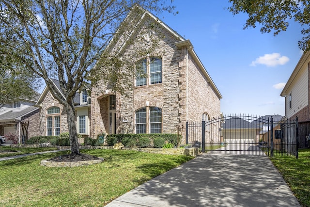 traditional-style home featuring a front yard, a gate, stone siding, and driveway