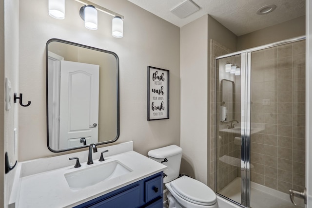 full bath with visible vents, a shower stall, toilet, vanity, and a textured ceiling