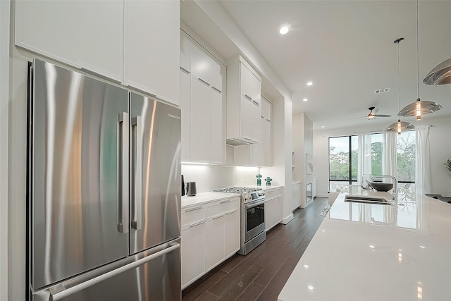 kitchen with visible vents, a sink, stainless steel appliances, light countertops, and dark wood-type flooring