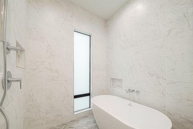 bathroom featuring tile walls, walk in shower, and a freestanding bath