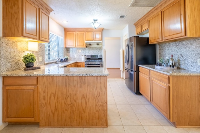 kitchen featuring visible vents, a peninsula, a sink, under cabinet range hood, and appliances with stainless steel finishes