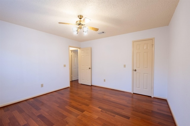 spare room featuring ceiling fan, visible vents, baseboards, and wood finished floors