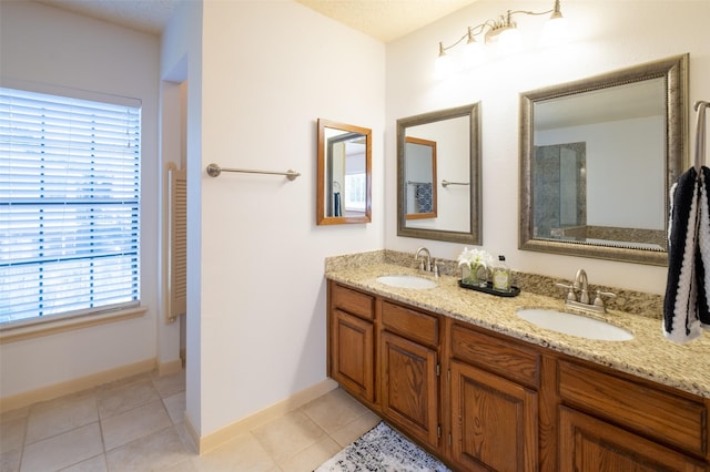 bathroom featuring tile patterned flooring, double vanity, and a sink