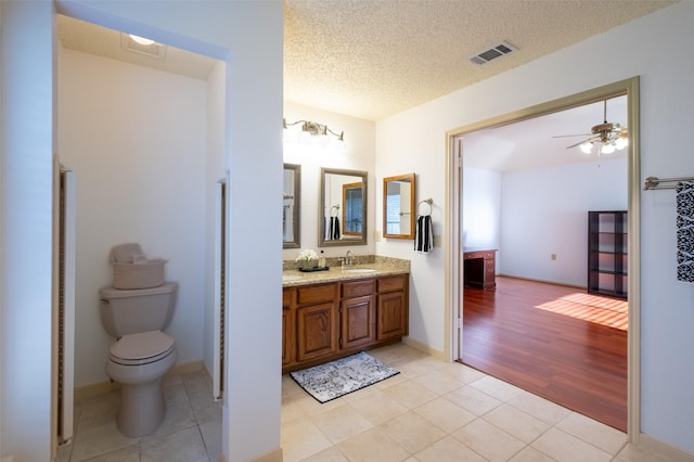 bathroom featuring tile patterned floors, visible vents, toilet, a textured ceiling, and vanity