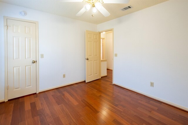 unfurnished bedroom with visible vents, a ceiling fan, baseboards, and wood finished floors