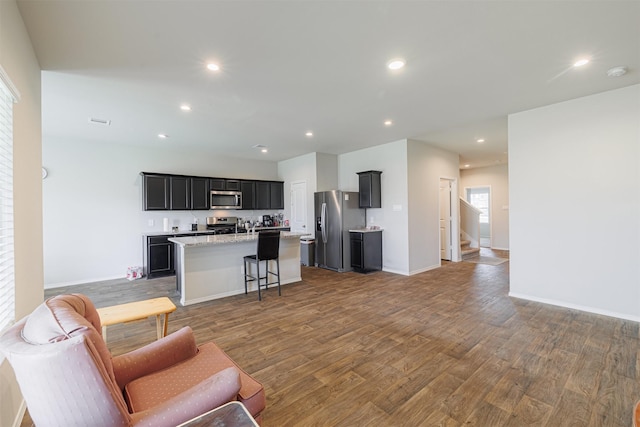 living area featuring recessed lighting, baseboards, wood finished floors, and stairs