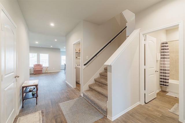 stairs featuring recessed lighting, wood finished floors, and baseboards