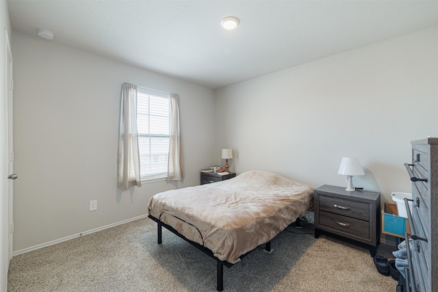 bedroom with baseboards and light carpet