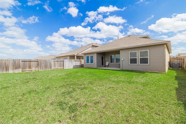 rear view of property with a patio, central AC, a lawn, and a fenced backyard