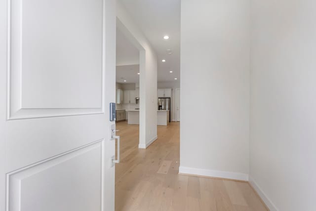 hallway featuring recessed lighting, light wood-type flooring, and baseboards