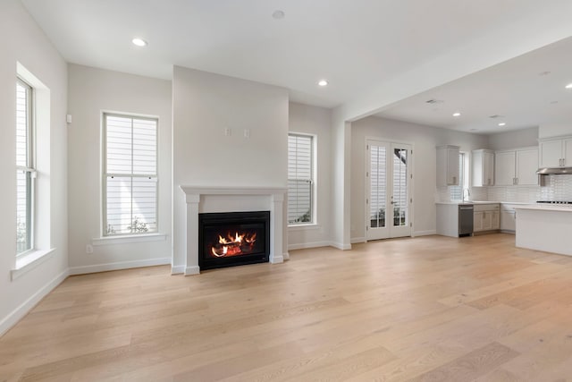 unfurnished living room with a wealth of natural light, light wood-style floors, and recessed lighting