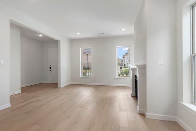 unfurnished living room with visible vents, baseboards, light wood-style flooring, recessed lighting, and a fireplace