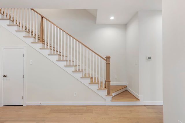 stairs with recessed lighting, baseboards, and wood finished floors