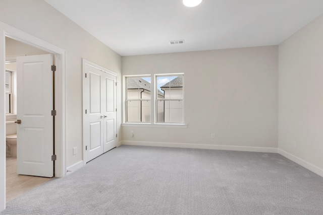 unfurnished bedroom with visible vents, baseboards, and light colored carpet