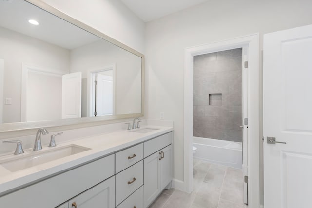 bathroom featuring double vanity, toilet, and a sink