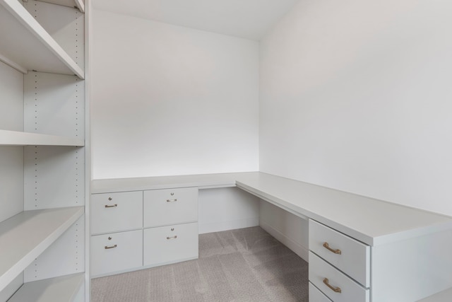 unfurnished office featuring light colored carpet and built in study area