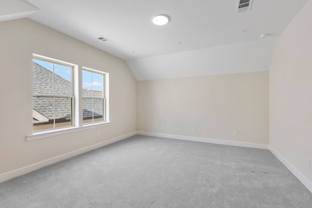 additional living space featuring visible vents, lofted ceiling, baseboards, and carpet flooring