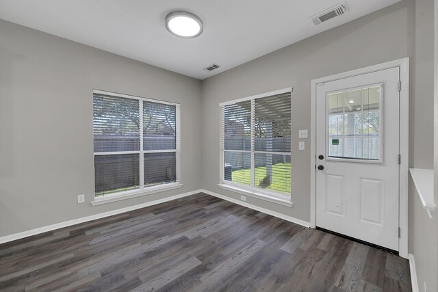 entryway with dark wood finished floors, visible vents, and baseboards