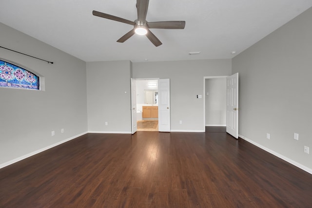 unfurnished bedroom featuring visible vents, baseboards, ensuite bath, dark wood-style flooring, and ceiling fan