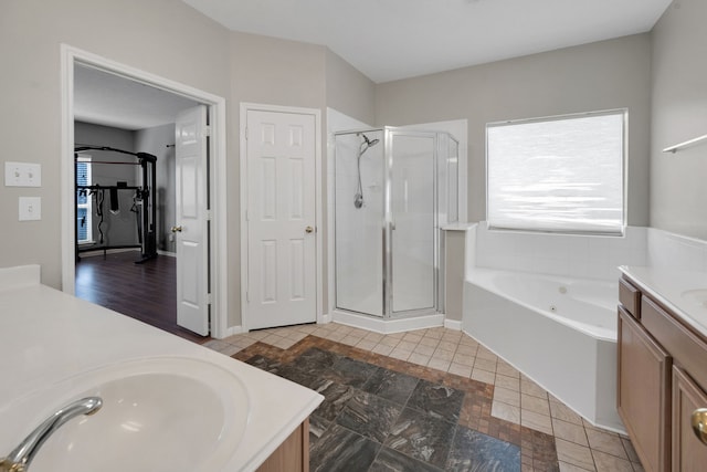 bathroom with a bath, tile patterned flooring, a shower stall, and vanity