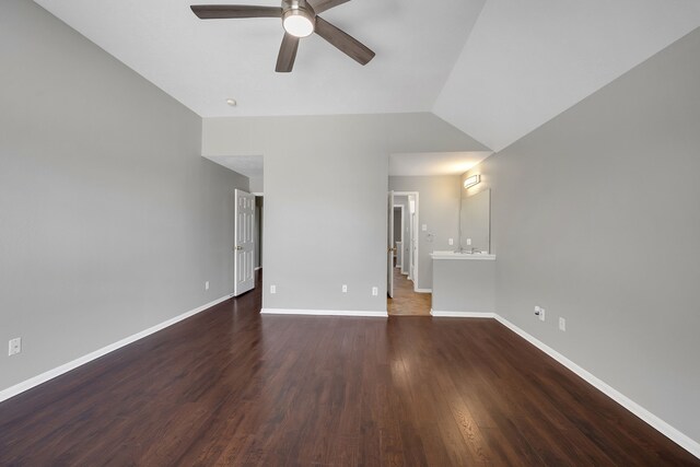 spare room with a ceiling fan, vaulted ceiling, wood finished floors, and baseboards