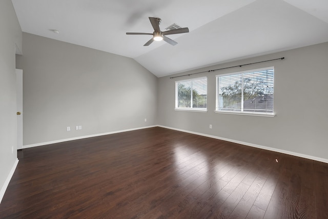 empty room featuring baseboards, lofted ceiling, dark wood-type flooring, and ceiling fan