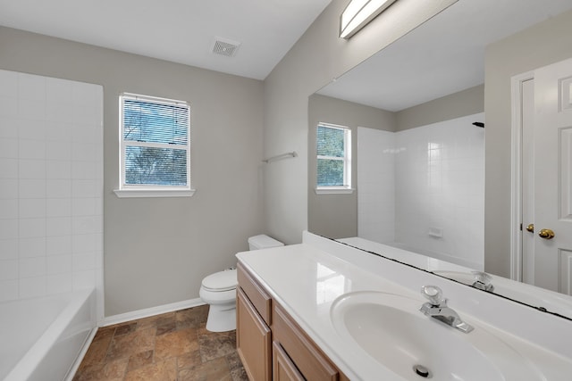 bathroom with vanity, visible vents, baseboards, stone finish floor, and toilet