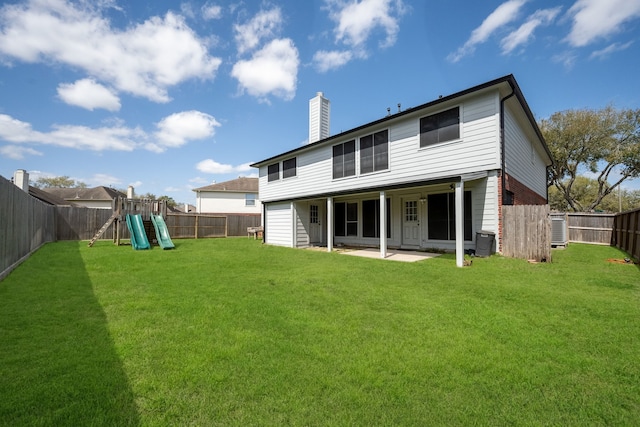 rear view of property with a patio, a lawn, a fenced backyard, and a playground