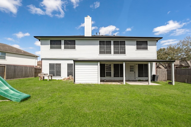 rear view of house with a patio, a fenced backyard, a chimney, a playground, and a lawn