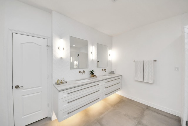 bathroom featuring double vanity, baseboards, and a sink