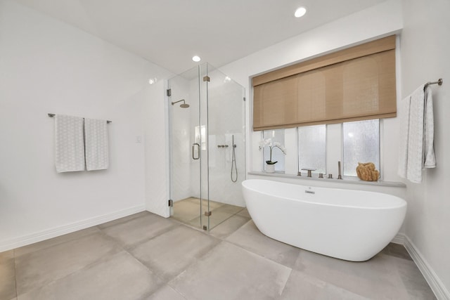 bathroom featuring recessed lighting, a shower stall, baseboards, and a freestanding tub