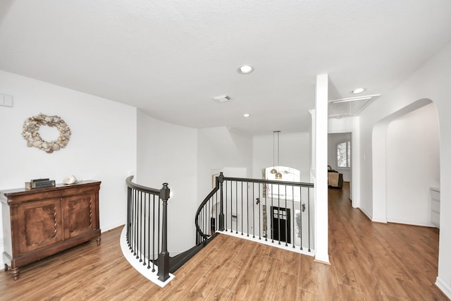 hallway featuring visible vents, an upstairs landing, light wood-style flooring, recessed lighting, and attic access