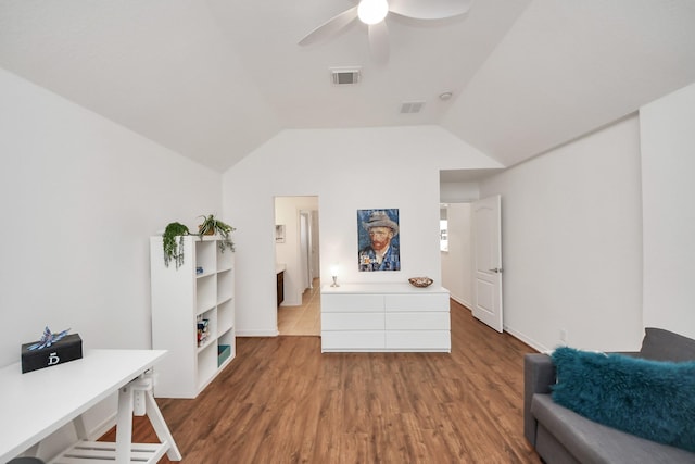 sitting room with ceiling fan, visible vents, wood finished floors, and vaulted ceiling