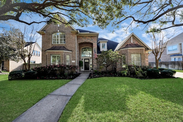 traditional-style house with a front lawn, fence, and brick siding