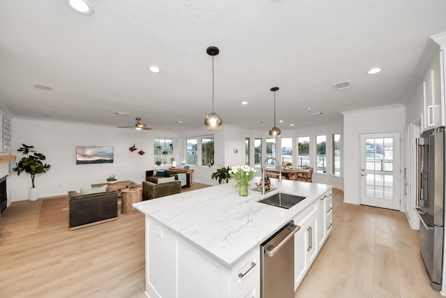 kitchen featuring white cabinets, appliances with stainless steel finishes, light wood-style floors, and a sink