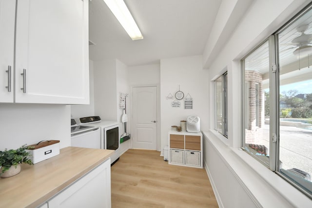 kitchen with white cabinetry, light countertops, independent washer and dryer, and light wood-type flooring