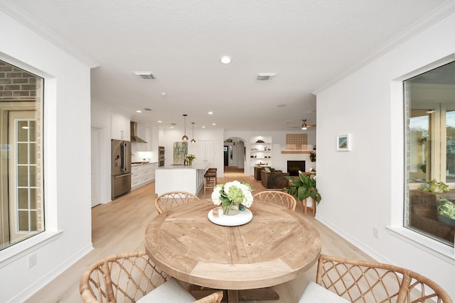 dining space with visible vents, arched walkways, and ornamental molding