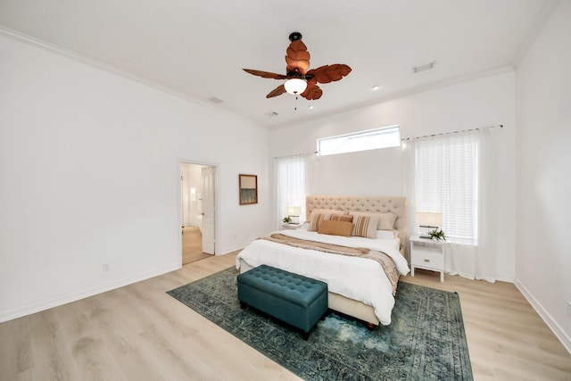 bedroom featuring visible vents, baseboards, light wood-style floors, and ornamental molding