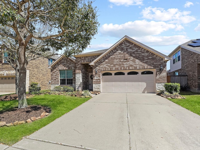 french country style house with brick siding, concrete driveway, a garage, and a front yard