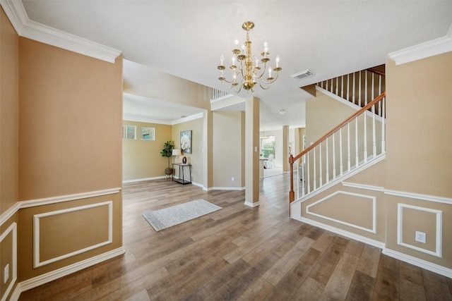 foyer featuring visible vents, a healthy amount of sunlight, stairway, and wood finished floors