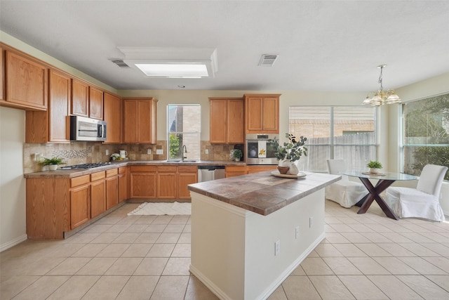 kitchen with visible vents, a sink, tasteful backsplash, appliances with stainless steel finishes, and light tile patterned floors